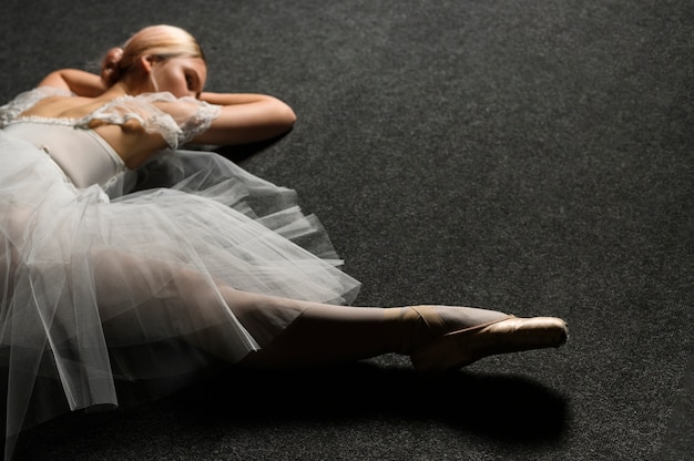 Angle élevé de ballerine en robe tutu faisant une scission