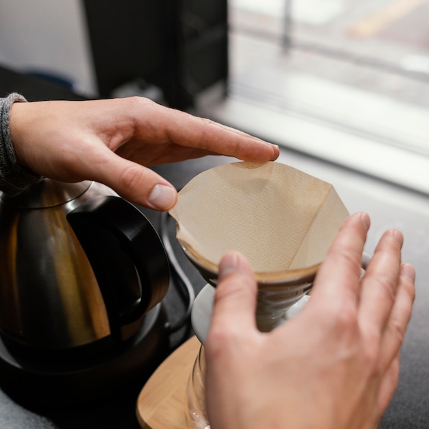 Angle élevé de barista mâle préparant le filtre à café