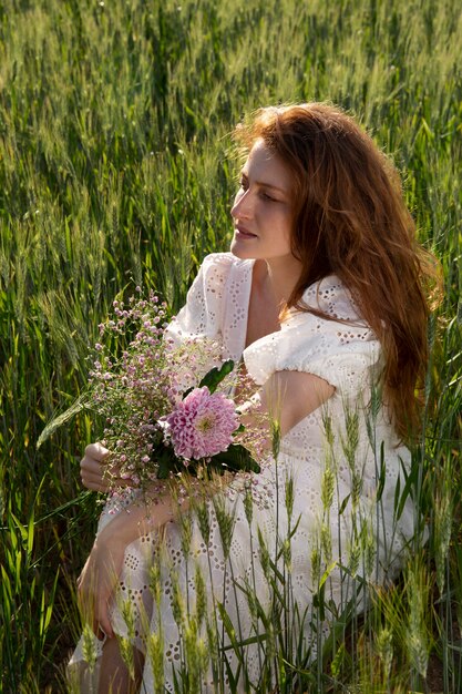 Angle élevé belle femme allongée sur l'herbe