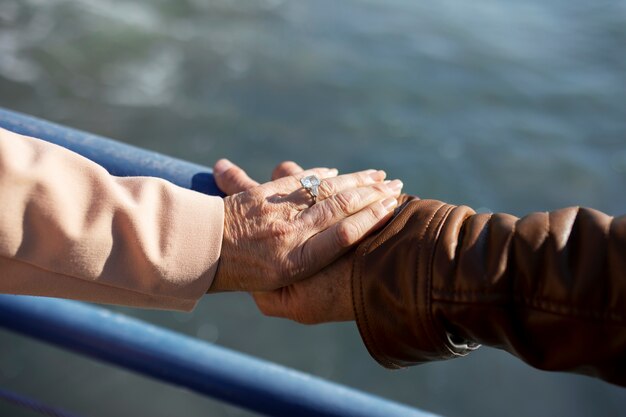Angle élevé de couple de personnes âgées main dans la main