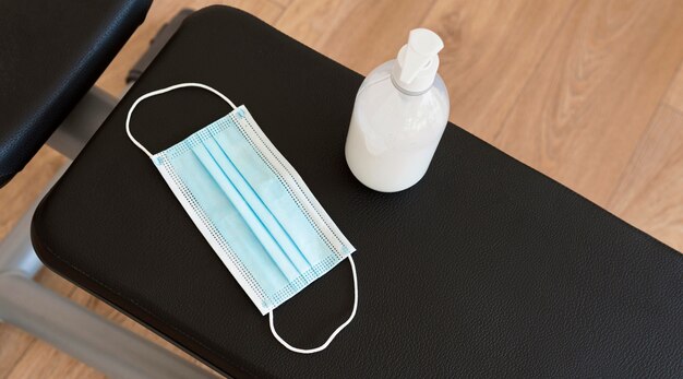 Angle élevé de désinfectant pour les mains et masque médical sur banc de gym