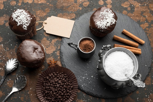 Angle élevé de desserts au chocolat avec des flocons de noix de coco et des bâtons de cannelle