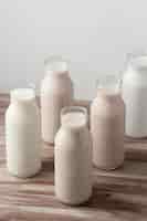 Photo gratuite angle élevé de différents types de lait en bouteilles