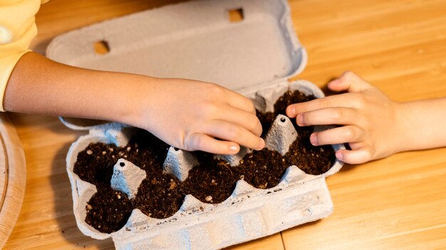 Angle élevé d'enfants plantant des graines à la maison