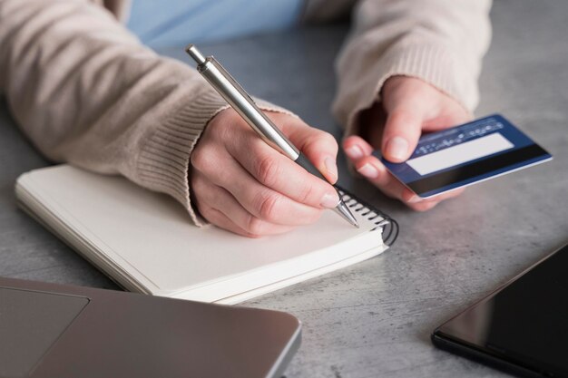 Angle élevé de femme avec carnet et carte de crédit