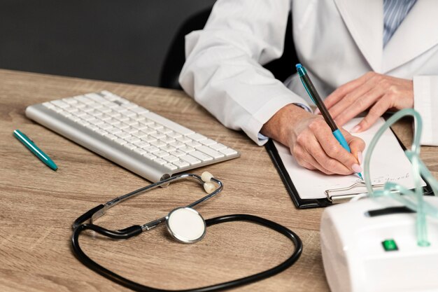 Angle élevé de femme médecin écrit une ordonnance au bureau