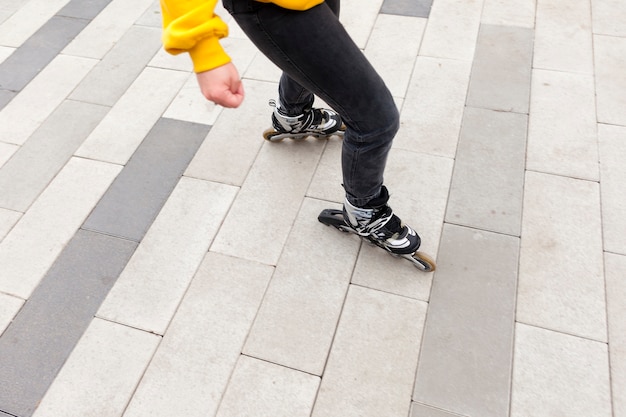 Angle élevé de femme avec des patins à roues alignées sur la chaussée