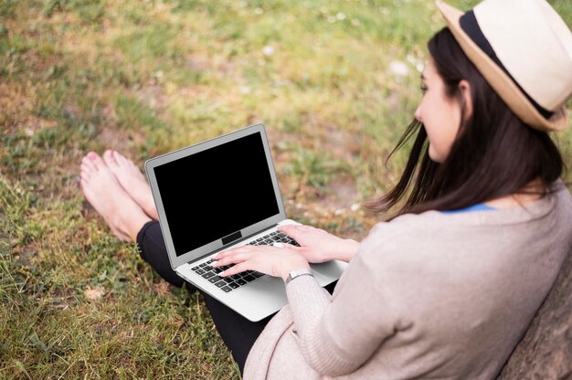 Angle élevé de femme travaillant sur un ordinateur portable à l'extérieur