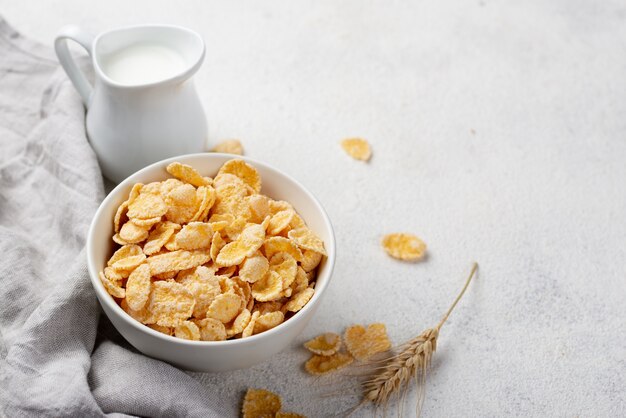 Angle élevé de flocons de maïs de petit déjeuner avec du lait et de l'espace de copie