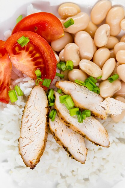 Angle élevé de haricots avec de la viande et des tomates sur du riz