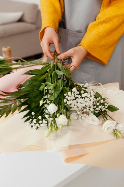 Angle élevé de jeune femme faisant un arrangement de fleurs