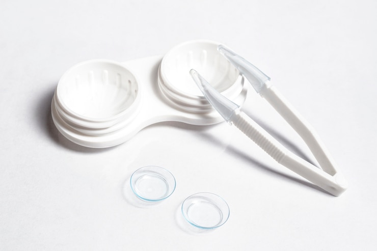 Photo gratuit angle élevé de lentilles de contact transparentes avec étui et pince à épiler