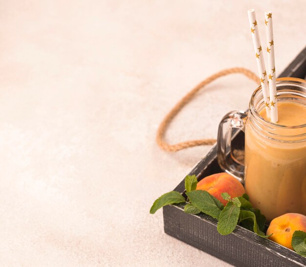 Angle élevé de milkshake à la pêche avec des pailles et de l'espace de copie