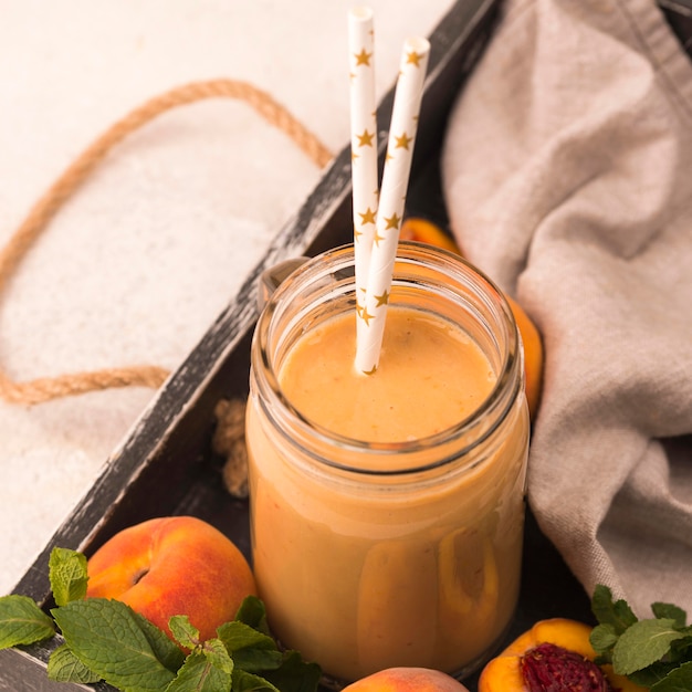 Photo gratuite angle élevé de milkshake avec des pêches et des pailles