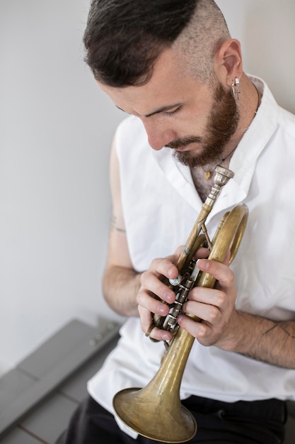 Photo gratuite angle élevé de musicien masculin jouant cornet