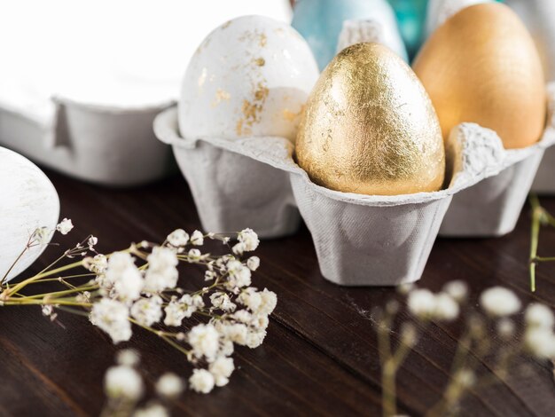 Angle élevé d'oeufs de Pâques colorés en carton avec gypsophile défocalisé