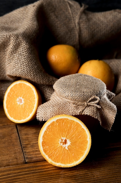 Angle élevé d'oranges avec toile de jute et pot de marmelade