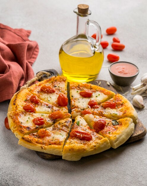 Angle élevé de pizza coupée en tranches avec de l'huile et des tomates