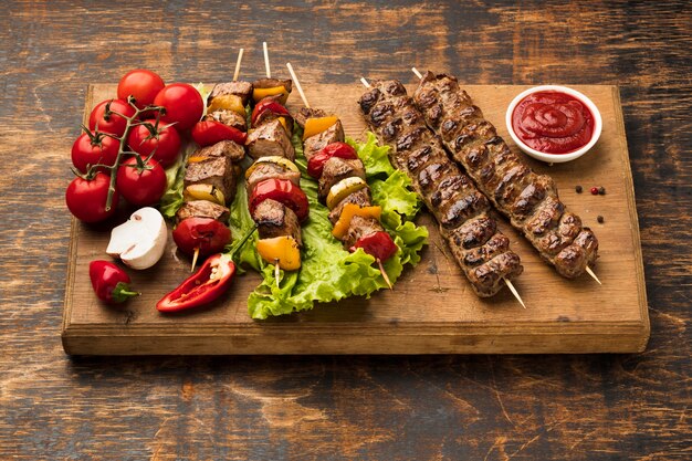 Angle élevé de planche à découper avec de délicieux kebab et légumes