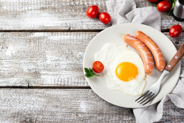 Angle élevé de plaque avec des saucisses et des œufs pour le petit déjeuner