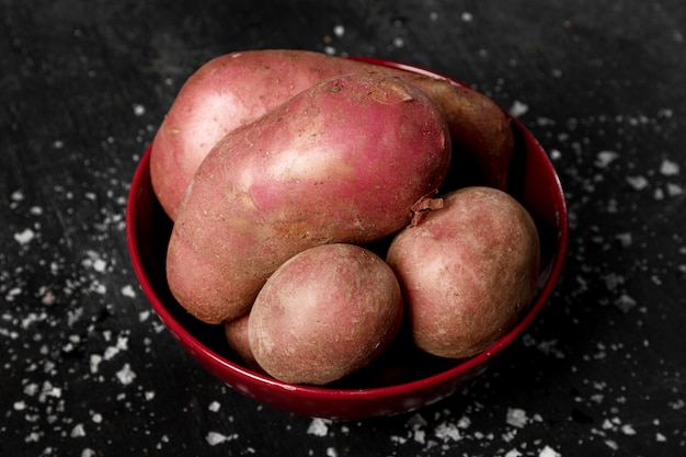 Angle élevé de pommes de terre dans un bol avec du sel