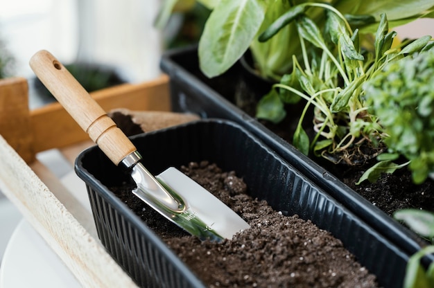 Photo gratuite angle élevé de pot de fleurs avec de la terre et une truelle