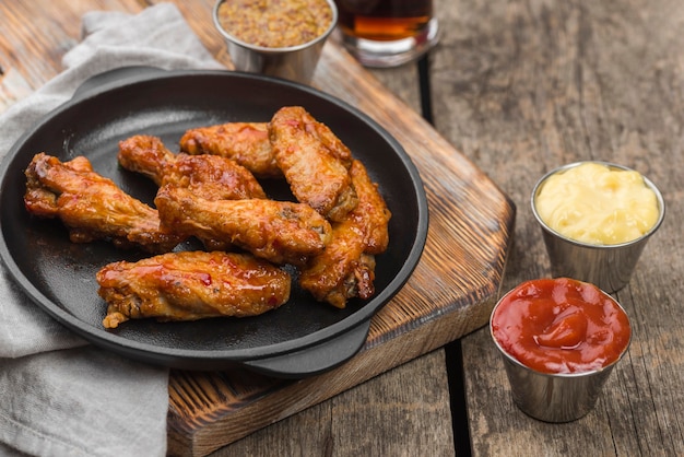 Angle élevé de poulet frit sur une assiette avec une variété de sauces et de boissons gazeuses