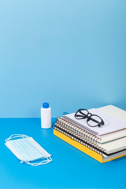 Photo gratuite angle élevé de retour à l'école avec un désinfectant pour les mains et un masque facial