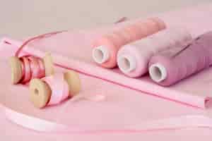 Photo gratuite angle élevé de rouleaux de fil rose avec tissu