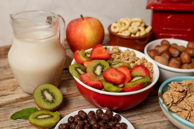 Angle élevé de sélection de céréales pour petit déjeuner dans un bol avec des fruits et du lait