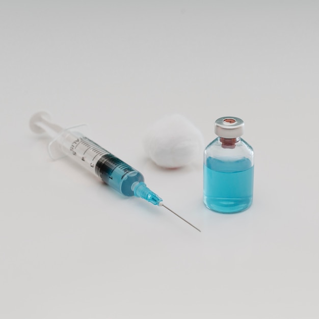 Photo gratuite angle élevé de seringue avec bouteille de coton et de vaccin