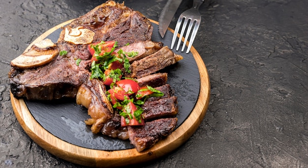 Angle élevé de steak avec couverts et espace copie