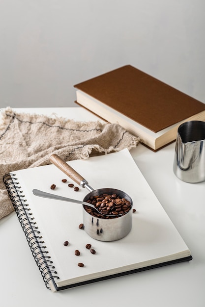 Angle élevé de tasse avec des grains de café sur un ordinateur portable