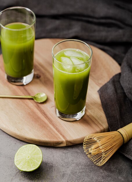 Angle élevé de thé matcha dans des verres avec des glaçons et du citron vert