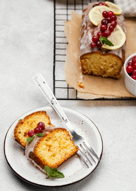 Angle élevé de tranches de gâteau sur une assiette avec des baies et une fourchette