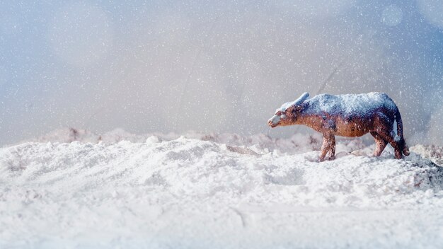 Animal jouet sur la berge de neige et de flocons de neige