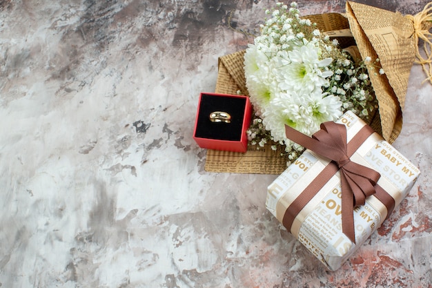 Anneau de bouquet de fleurs vue de dessus dans une petite boîte cadeau sur table avec espace libre