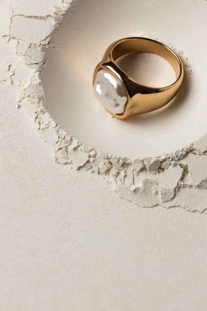 Photo gratuite anneau d'or cher avec fond de poudre blanche