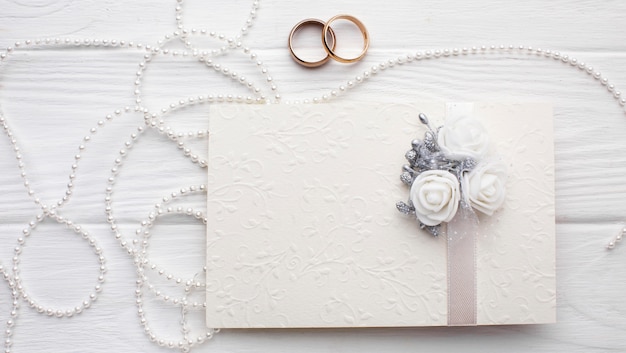 Photo gratuite anneaux de mariage et sonnettes avec enveloppe d'invitation