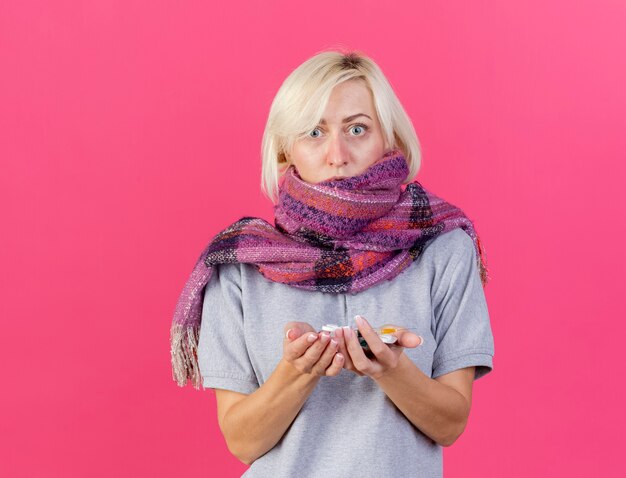 Anxieux jeune femme slave malade blonde portant un foulard détient des paquets de pilules médicales