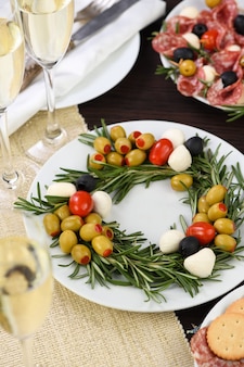 Un apéritif de romarin farci aux olives avec mini mozzarella et tomates cerises