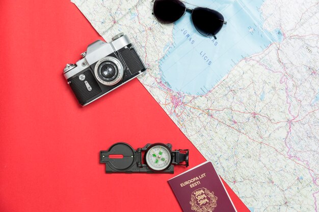 Appareil photo et passeport près de boussole et carte