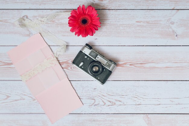 Appareil photo rétro près de papiers et de fleurs fraîches