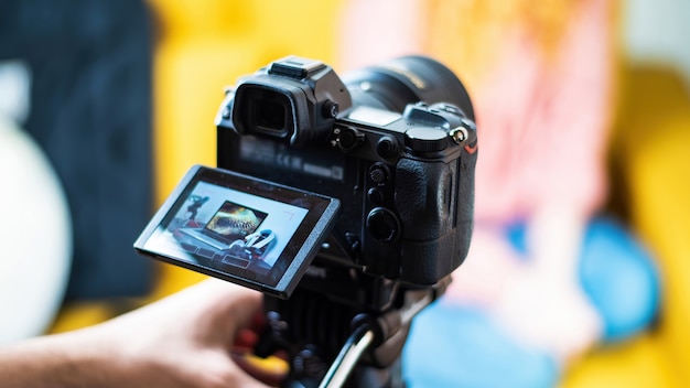 Appareil photo sur un trépied filmant une table avec des trucs de créateur de contenu. Ordinateur portable, microphone et écouteurs. Travailler à domicile