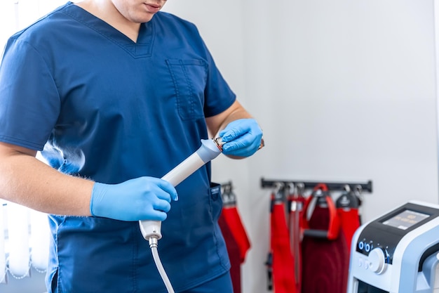 Photo gratuite appareil de thérapie par ondes de choc avec des mains de médecin masculin dans des gants en caoutchouc