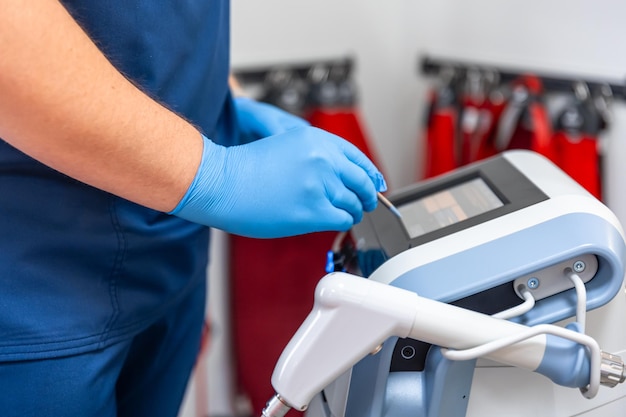 Photo gratuite appareil de thérapie par ondes de choc avec des mains de médecin masculin dans des gants en caoutchouc