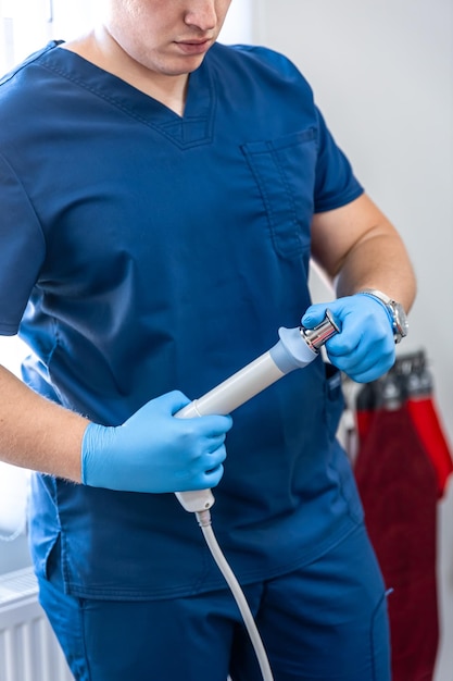 Photo gratuite appareil de thérapie par ondes de choc avec des mains de médecin masculin dans des gants en caoutchouc