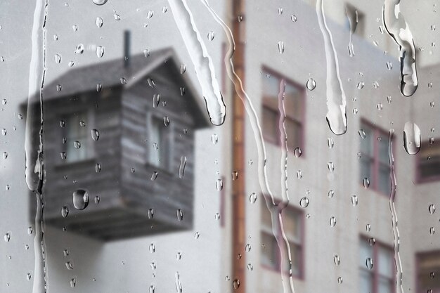 Appartement blanc à travers la fenêtre avec des gouttes de pluie