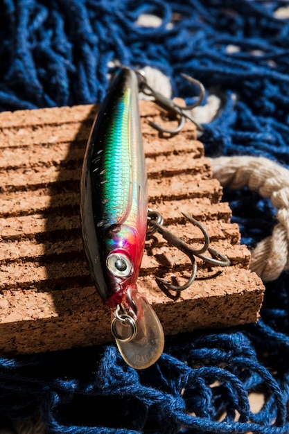 Appâts de pêche colorés sur tableau de liège sur le filet de pêche