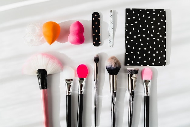 Photo gratuite applicateurs de maquillage près de cahier